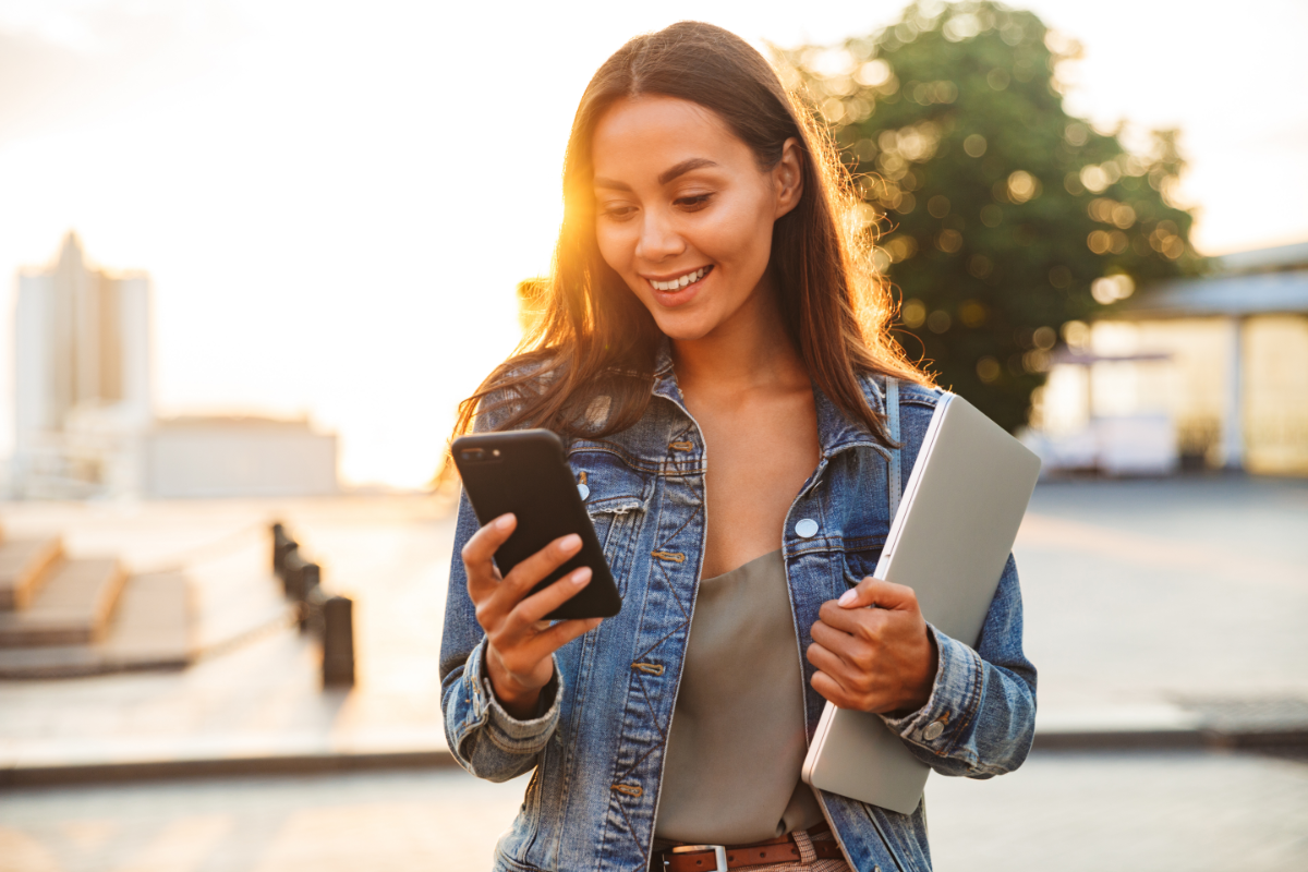 Kobieta patrzy na telefon i korzysta z aplikacji Booksy