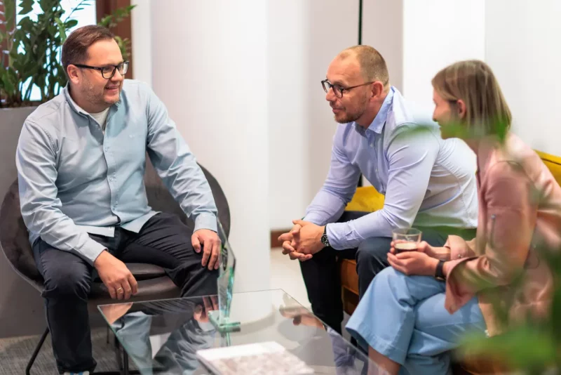 CEO i pracownicy Sales&More siedzą na kanapach i rozmawiają o digital marketingu