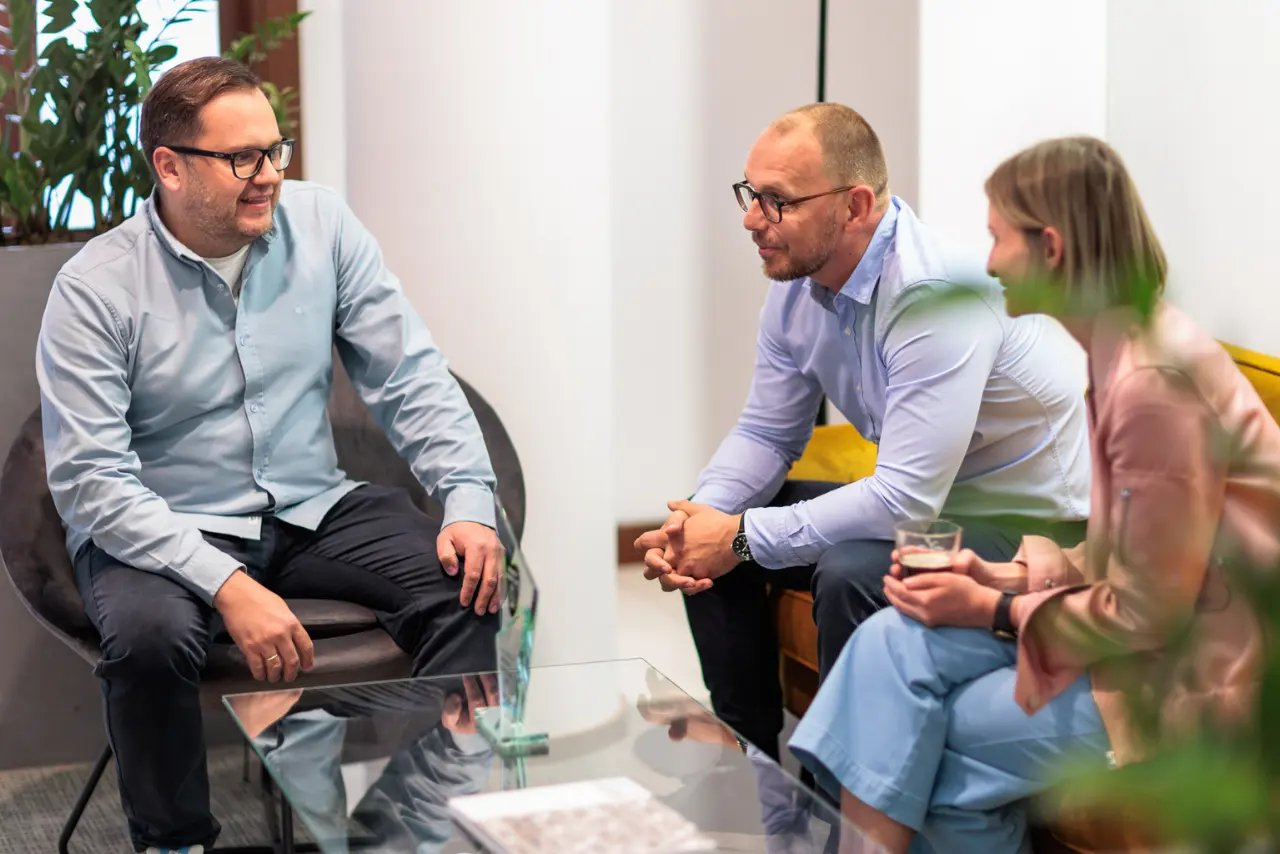 CEO i pracownicy Sales&More siedzą na kanapach i rozmawiają o digital marketingu