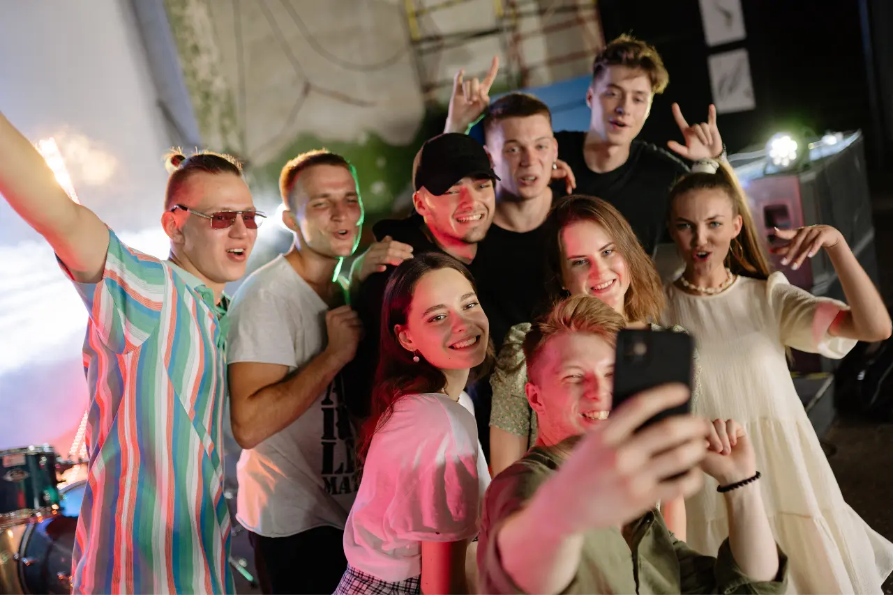 młodzi ludzie robią sobie selfie - zdjęcie jest ilustracją do artykułu omawiającego raport zachwania Polakó w SoMe