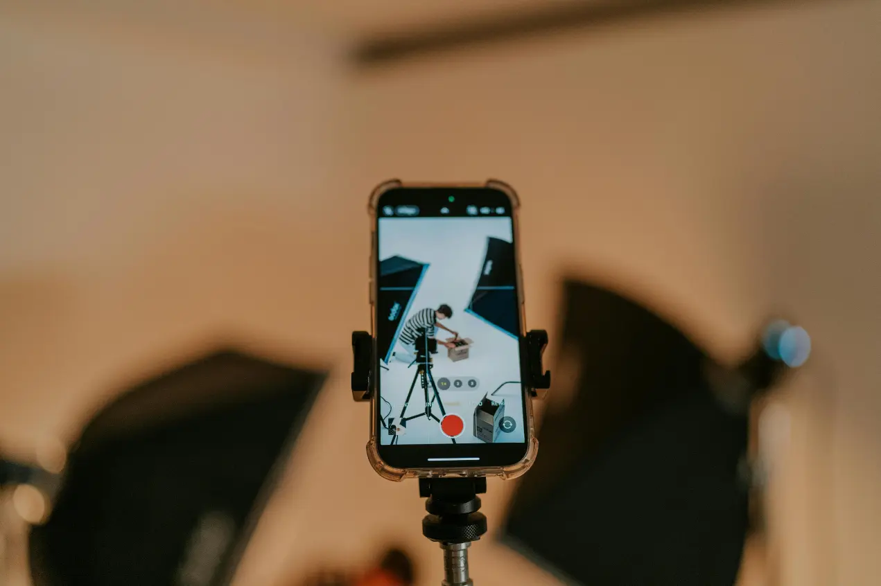 telefon na statywie, na którym widać sesję do reklamy graficznej oraz wideo